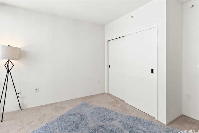 unfurnished room featuring light colored carpet