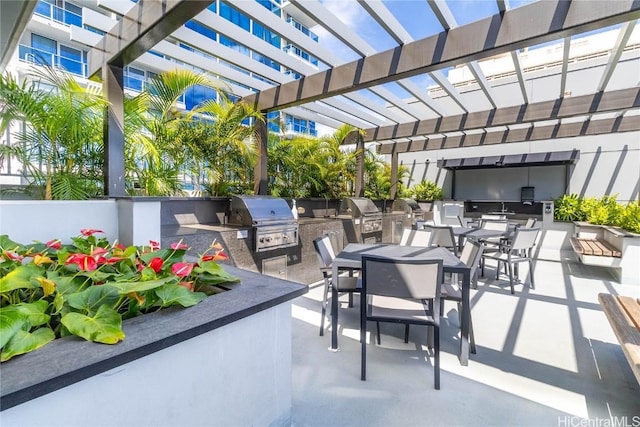 view of patio / terrace featuring a grill, a pergola, and an outdoor kitchen