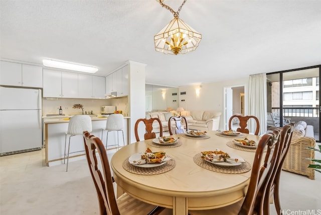 dining space with a textured ceiling, an inviting chandelier, and expansive windows