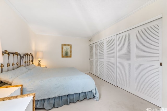 carpeted bedroom featuring crown molding and a closet