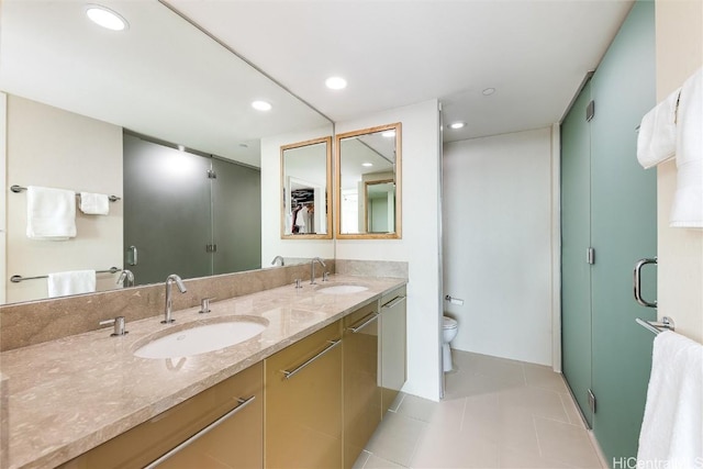 bathroom with tile patterned flooring, vanity, toilet, and an enclosed shower