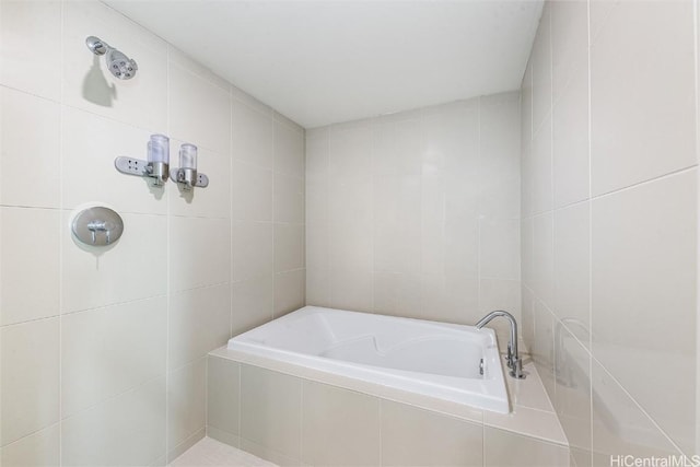 bathroom with a relaxing tiled tub and tile walls