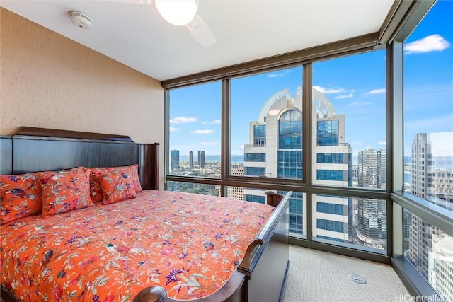 carpeted bedroom with multiple windows, ceiling fan, and expansive windows