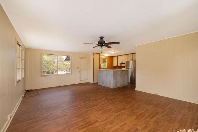 unfurnished living room featuring dark hardwood / wood-style floors and ceiling fan