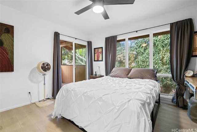 bedroom with ceiling fan, wood-type flooring, and multiple windows