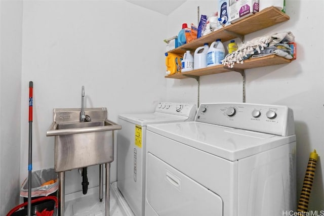 clothes washing area with washing machine and dryer and sink