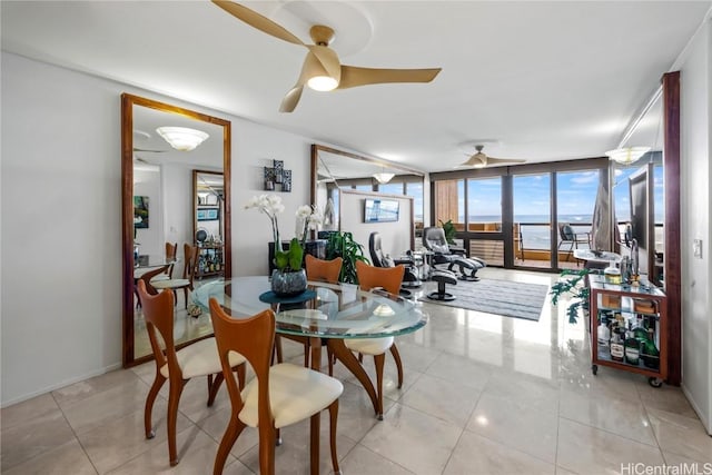 tiled dining area featuring a wall of windows and ceiling fan