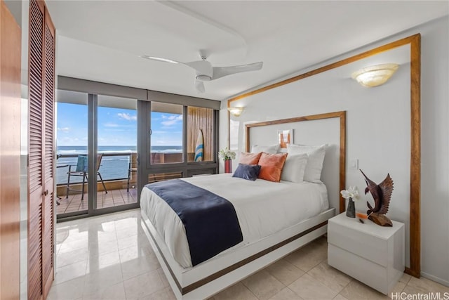 tiled bedroom featuring access to exterior, multiple windows, a water view, and ceiling fan