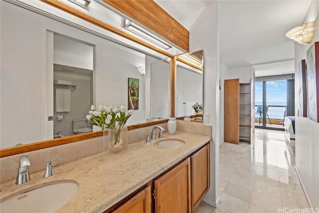 bathroom featuring a water view, vanity, and toilet