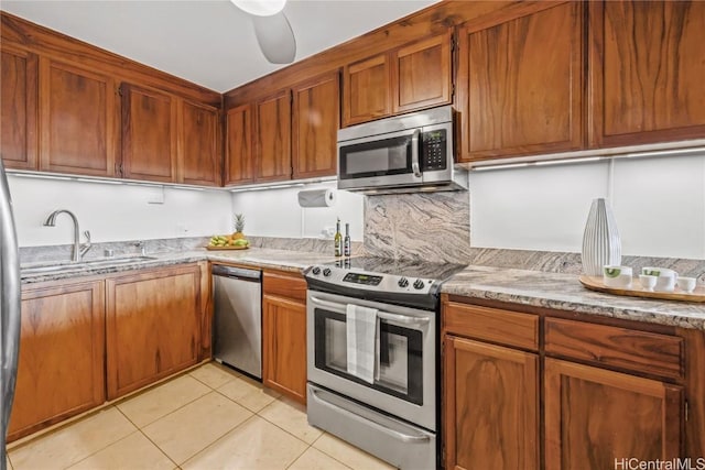 kitchen with sink, ceiling fan, decorative backsplash, light tile patterned floors, and stainless steel appliances