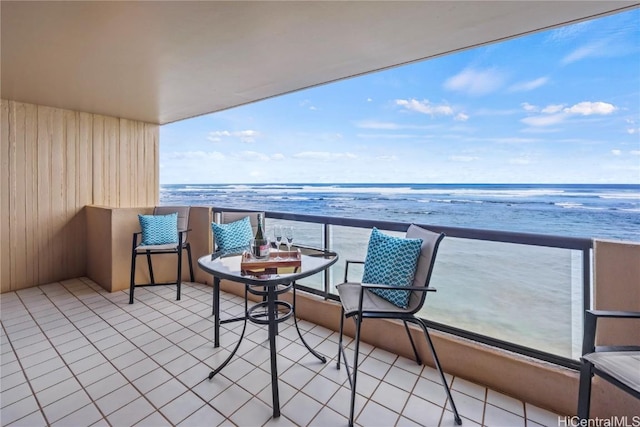 balcony featuring a view of the beach and a water view