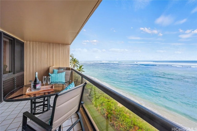 balcony with a water view and a view of the beach