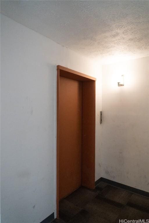 spare room featuring a textured ceiling and elevator