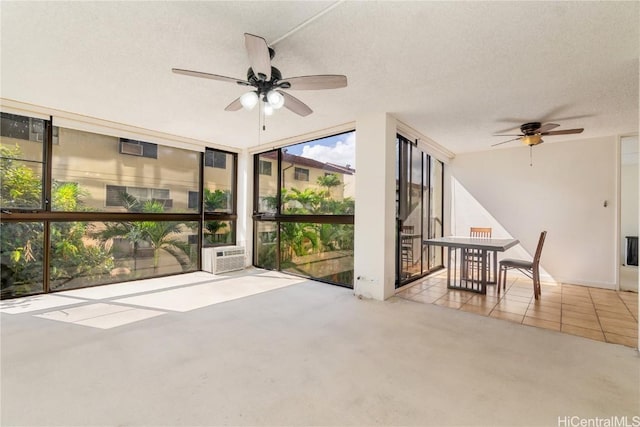 unfurnished sunroom featuring ceiling fan and cooling unit