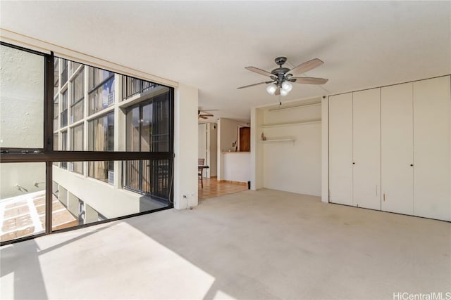 empty room with ceiling fan and light colored carpet