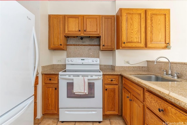 kitchen with white appliances, light stone countertops, light tile patterned flooring, and sink