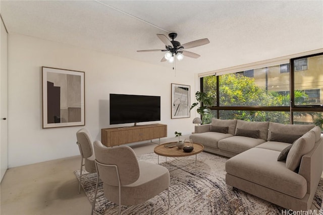 living room featuring ceiling fan, a textured ceiling, and expansive windows