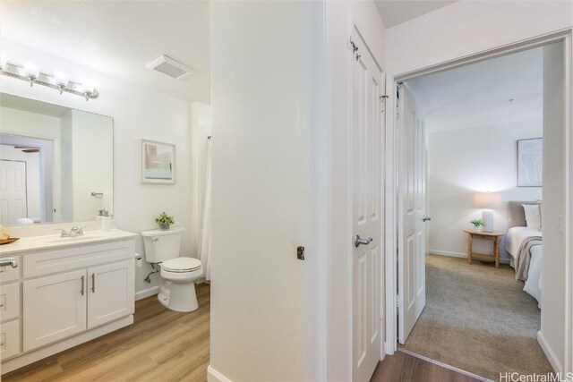 bathroom with vanity, hardwood / wood-style floors, and toilet