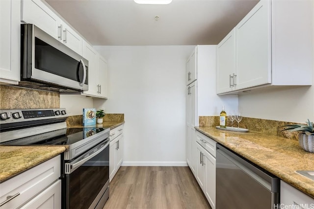 kitchen featuring light stone countertops, white cabinets, and appliances with stainless steel finishes