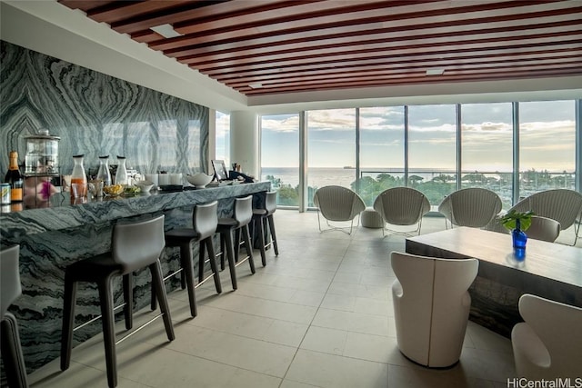 interior space with a water view, a healthy amount of sunlight, and beamed ceiling