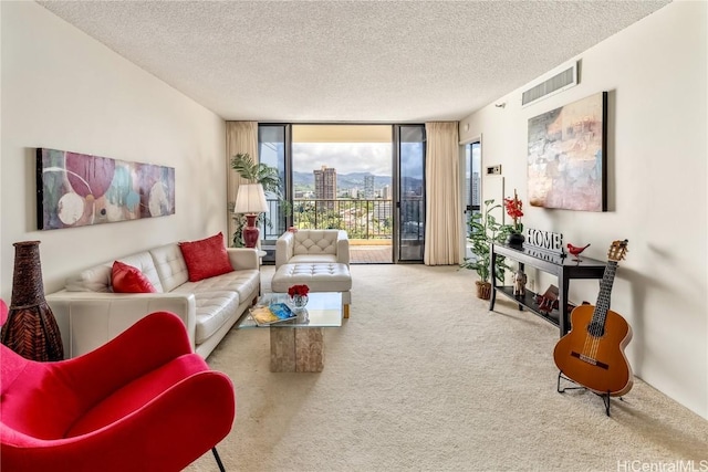 carpeted living area featuring expansive windows, a textured ceiling, visible vents, and a city view