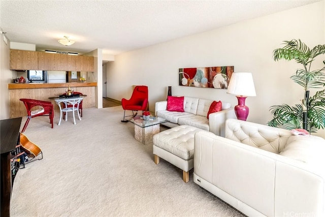 living room featuring light carpet and a textured ceiling