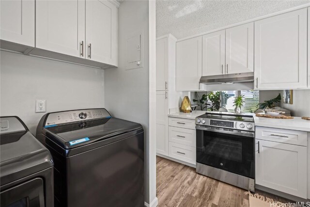 kitchen with white cabinetry, a textured ceiling, independent washer and dryer, light wood-type flooring, and stainless steel electric range oven