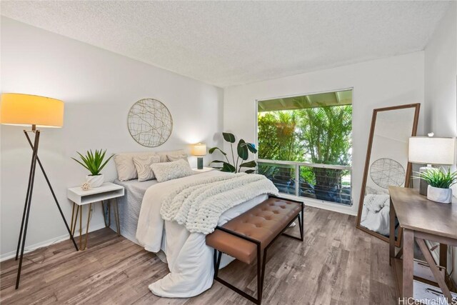 bedroom with a textured ceiling and hardwood / wood-style flooring