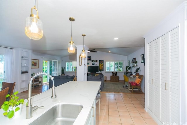 kitchen with pendant lighting, ceiling fan, sink, and vaulted ceiling