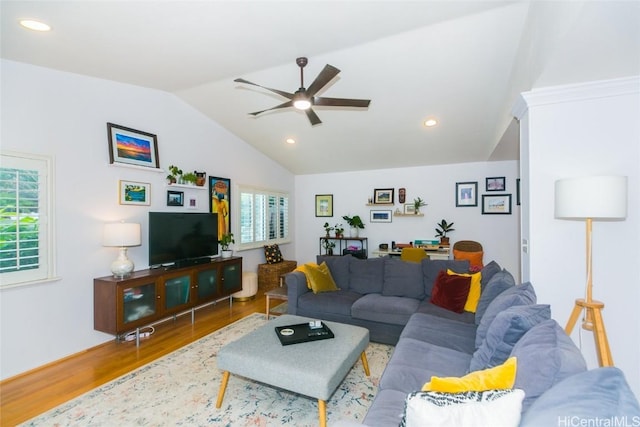 living room with hardwood / wood-style flooring, ceiling fan, and vaulted ceiling