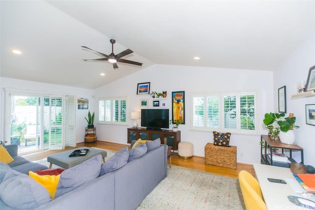 living room with a wealth of natural light, light hardwood / wood-style flooring, and lofted ceiling