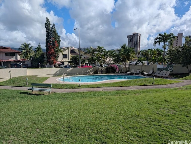 view of swimming pool with a yard