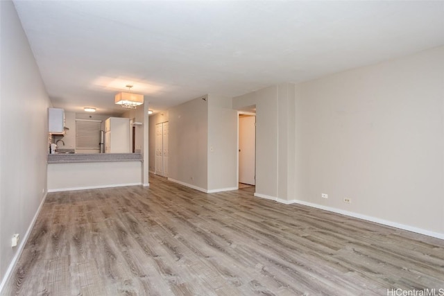 unfurnished living room featuring light hardwood / wood-style flooring and sink