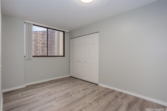 unfurnished bedroom featuring light hardwood / wood-style flooring and a closet