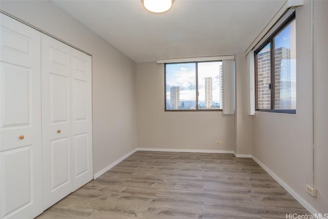 unfurnished bedroom featuring a closet and light wood-type flooring