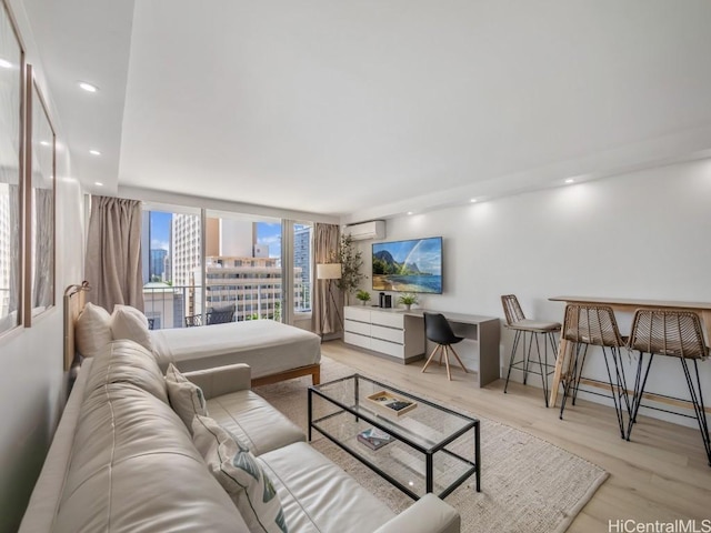 living room with light hardwood / wood-style floors and a wall unit AC