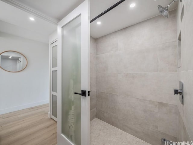 bathroom featuring a tile shower and hardwood / wood-style flooring