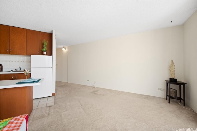 kitchen featuring white fridge, light colored carpet, and decorative backsplash