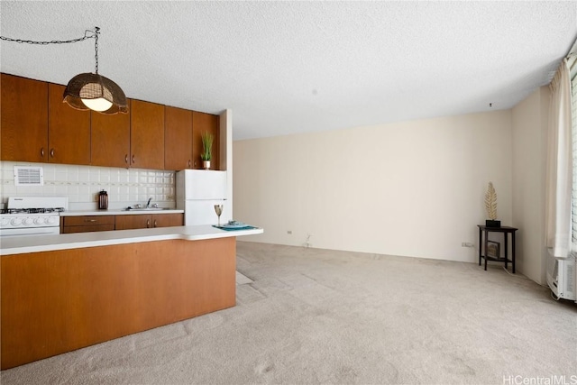 kitchen featuring sink, white appliances, decorative light fixtures, light colored carpet, and backsplash