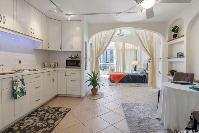 kitchen with ceiling fan, white cabinets, light tile patterned flooring, and tasteful backsplash