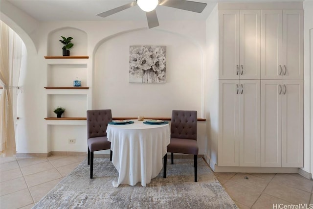 dining space with built in features, ceiling fan, and light tile patterned floors