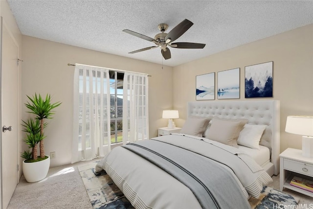 carpeted bedroom with ceiling fan and a textured ceiling