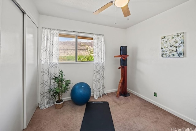 exercise area featuring ceiling fan and light carpet