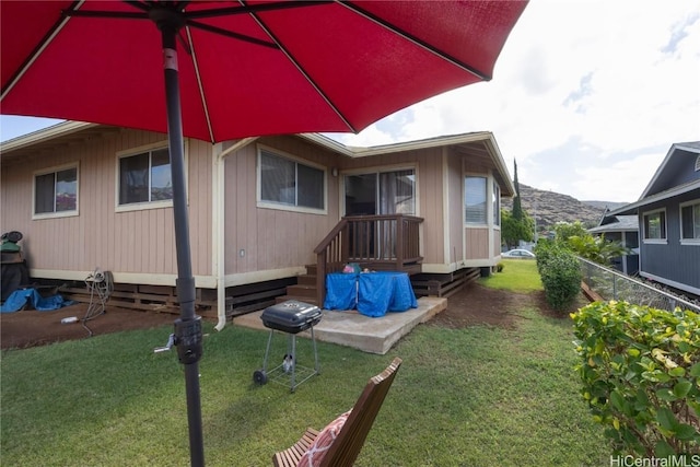 back of property with a yard and a patio