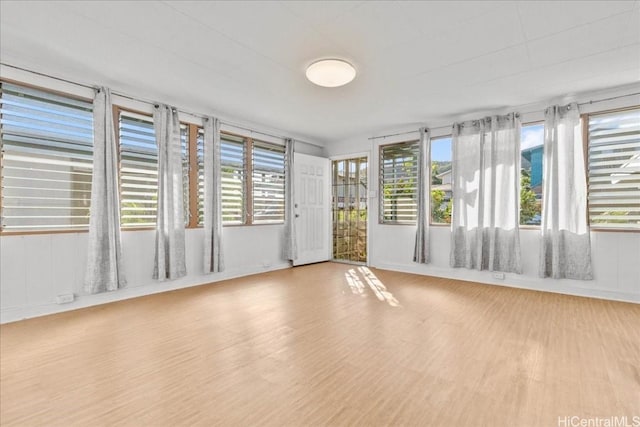 unfurnished room with light wood-type flooring and a healthy amount of sunlight