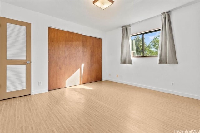 unfurnished bedroom featuring light hardwood / wood-style flooring and a closet