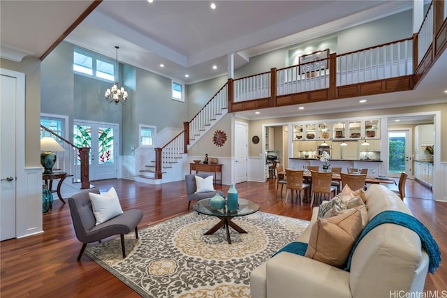 living room with an inviting chandelier, a healthy amount of sunlight, and a towering ceiling