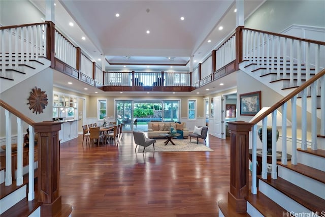 living room with a towering ceiling and hardwood / wood-style flooring