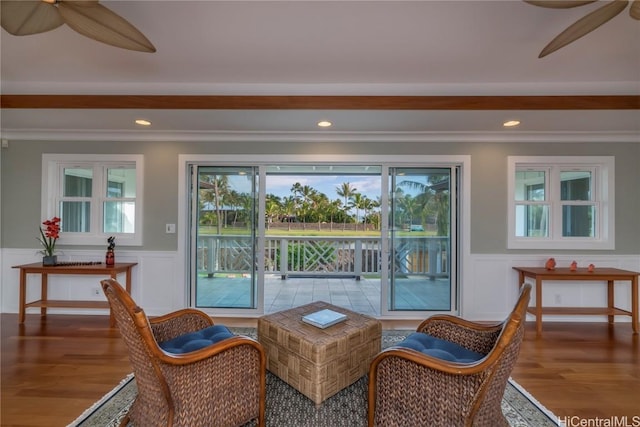 living area with ceiling fan, crown molding, and wood-type flooring