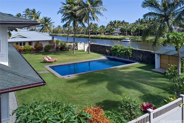 view of swimming pool with a water view and a lawn